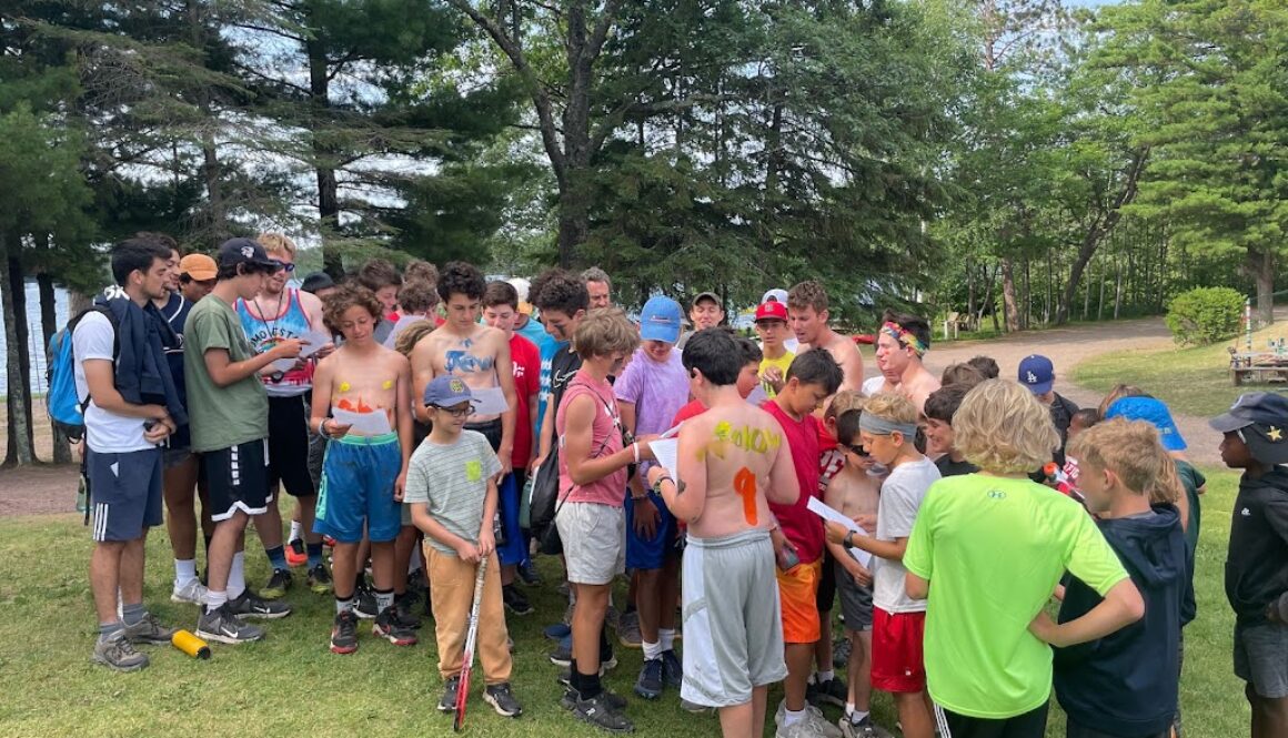 A group of campers read instructions while preparing for the camp tradition of United Nations Day at North Star Camp for Boys.