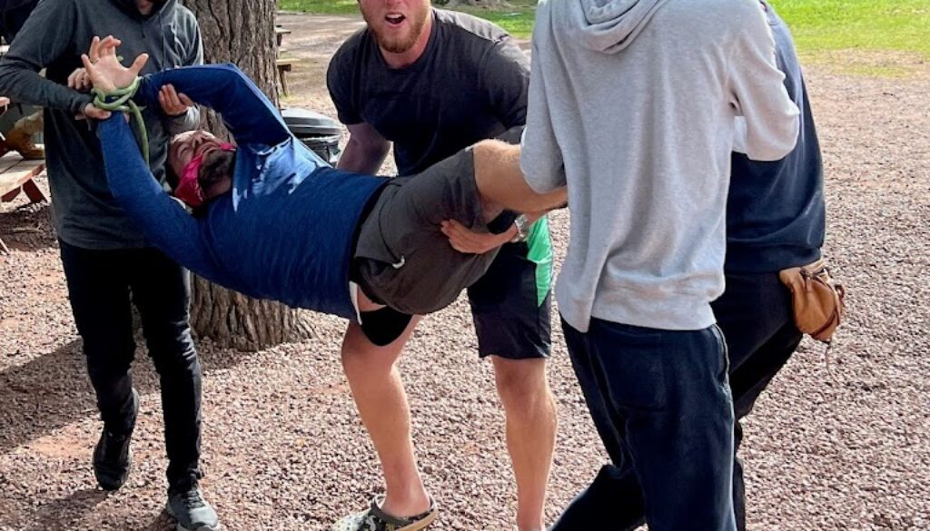 A group of campers and counselors carry a staff member during a camp activity at North Star Camp for Boys.