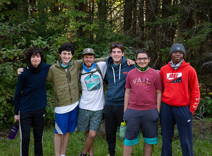 A group of campers and staff members smile for a photo during a wilderness hiking trip at North Star Camp for Boys.