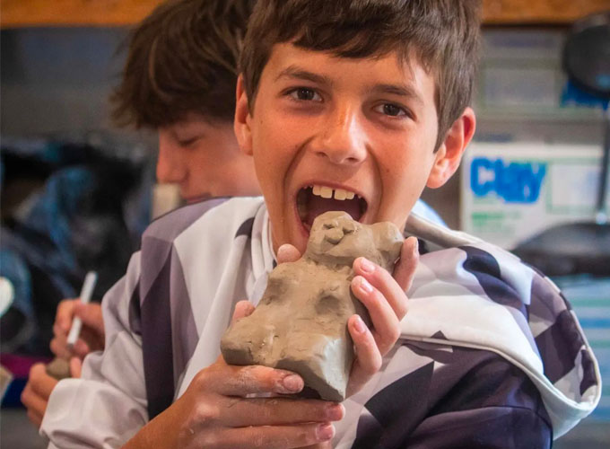 A camper at North Star Camp for Boys shows off a clay bear made during an arts and crafts activity.