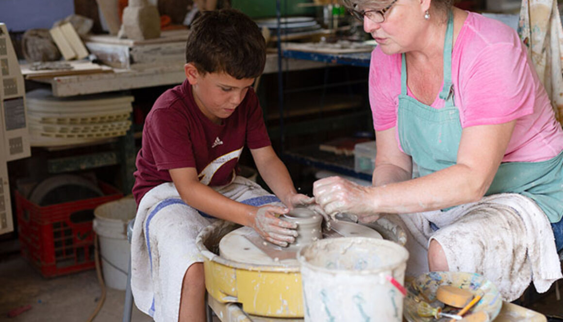 A camper learns how to use a pottery wheel with the help of an instructor at North Star Camp for Boys.