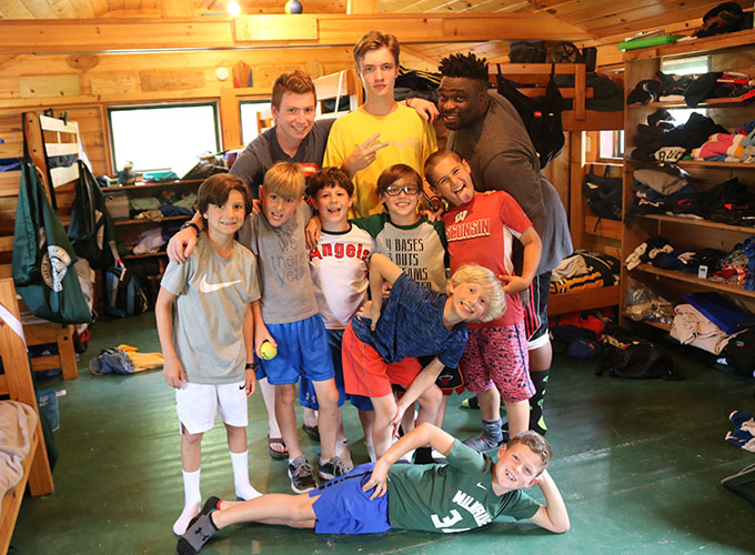 A group of campers and their counselors stand in their cabin at North Star Camp for Boys.