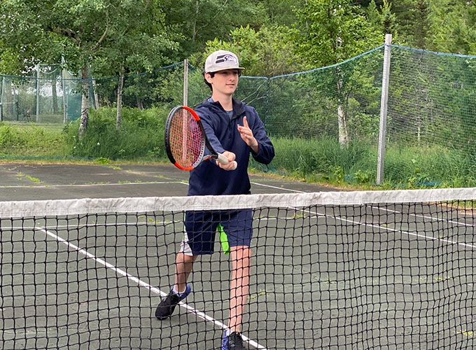 A camper stands close to the net as he prepares for the next move from his opponent during a game of tennis at North Star Camp for Boys.