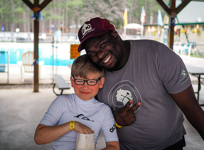 A camper and staff member smile together at North Star Camp for Boys.