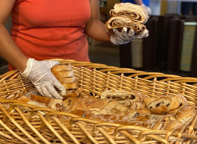 A kitchen staff member prepares to serve homemade cinnamon bread.
