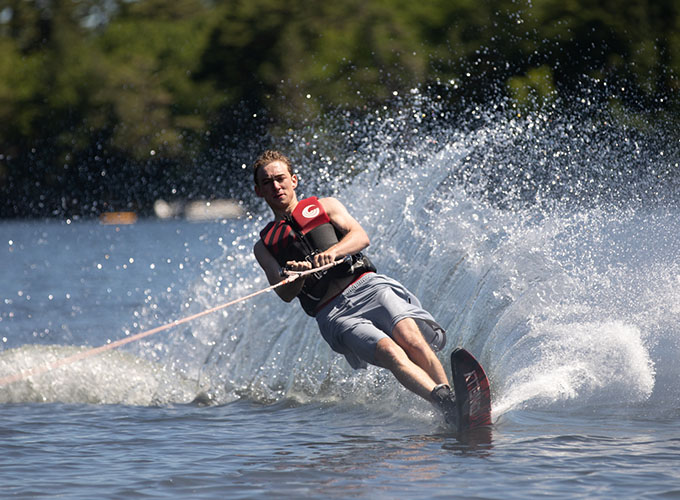 A camper leaves a wave-like trail in his path as he waterskies through Spider Lake at North Star Camp for Boys.