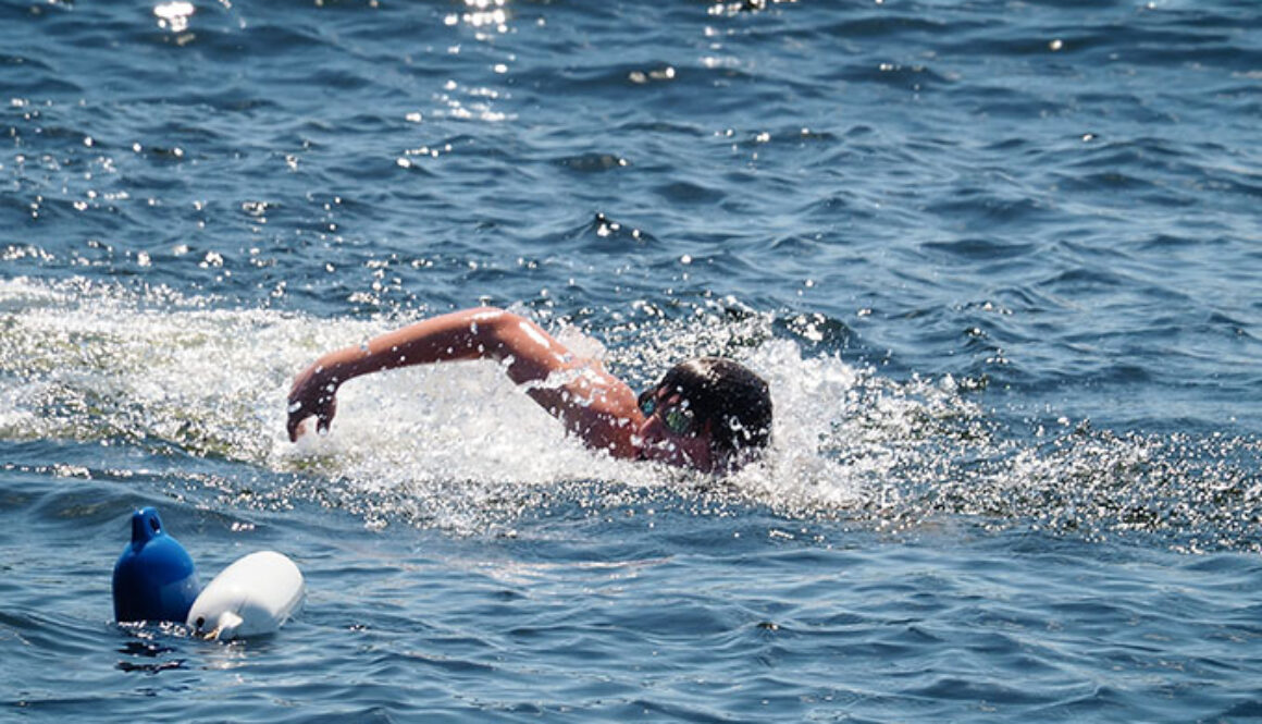 A camper raises his arm out of the water as he participates in a swimming activity in Spider Lake at North Star Camp for Boys.