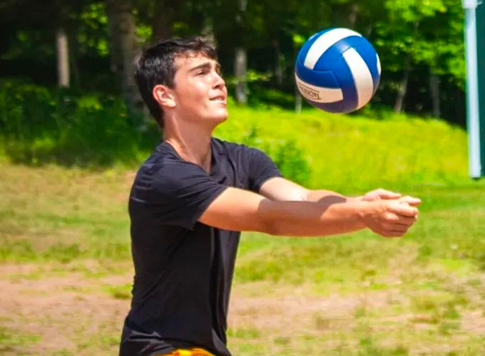 A camper bumps a volleyball during a game at North Star Camp for Boys.