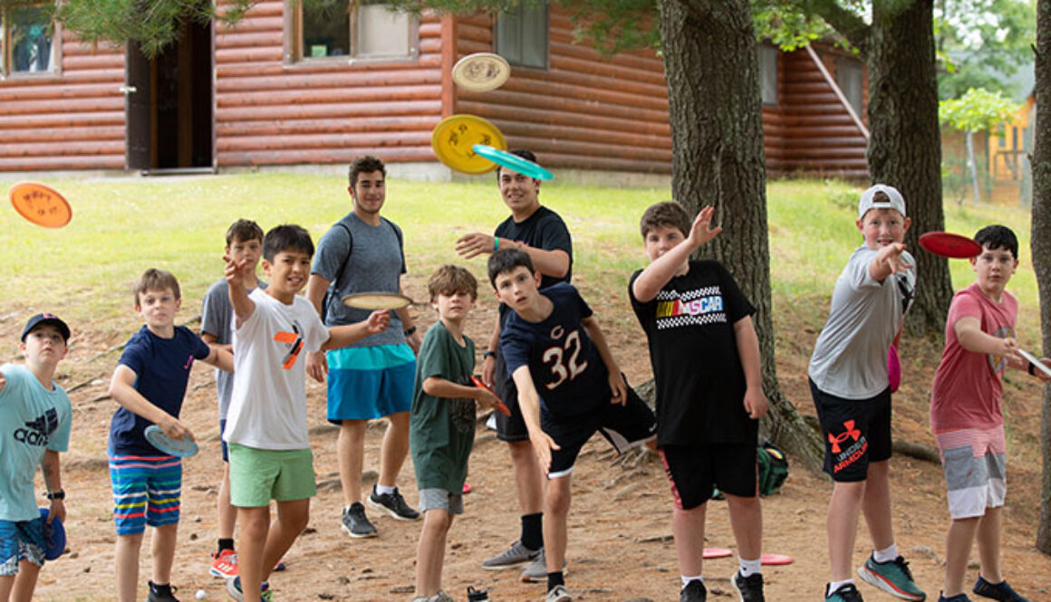 Campers standing in a line throwing frisbees at North Star Camp for Boys.