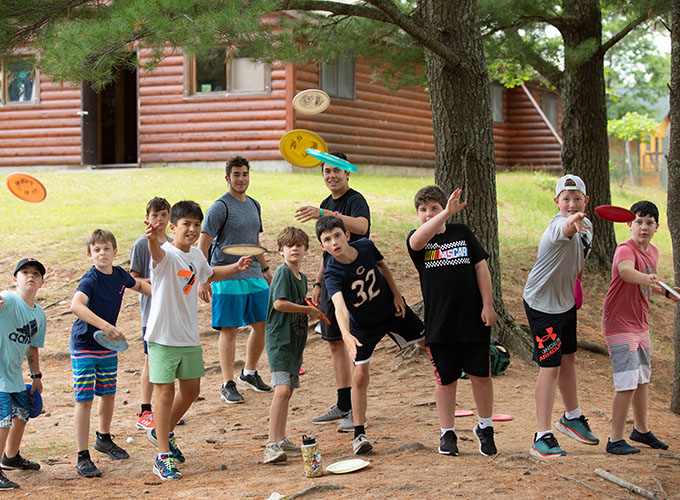 Campers standing in a line throwing frisbees at North Star Camp for Boys.