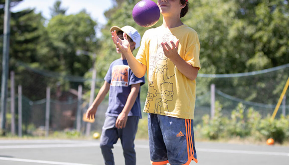 A camper tosses a purple foam ball in the air in between rounds of dodgeball at North Star Camp for Boys.