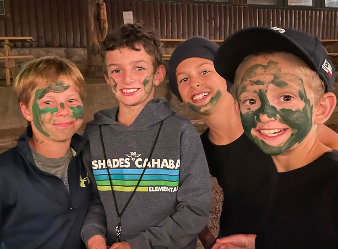 A group of campers smile for a photo wearing green face paint during a game of Espionage at North Star Camp for Boys.