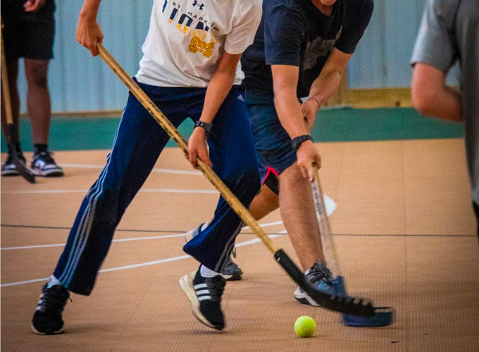 Campers compete in a game of floor hockey while one tries to intercept the ball from the other one at North Star Camp for Boys.