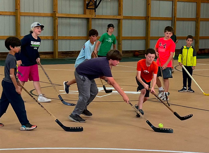 Campers practice their hockey stick handling skills during a game of indoor floor hockey at North Star Camp for Boys.