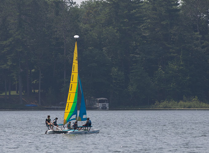 A group of campers sit in a still sailboat at North Star Camp for Boys.