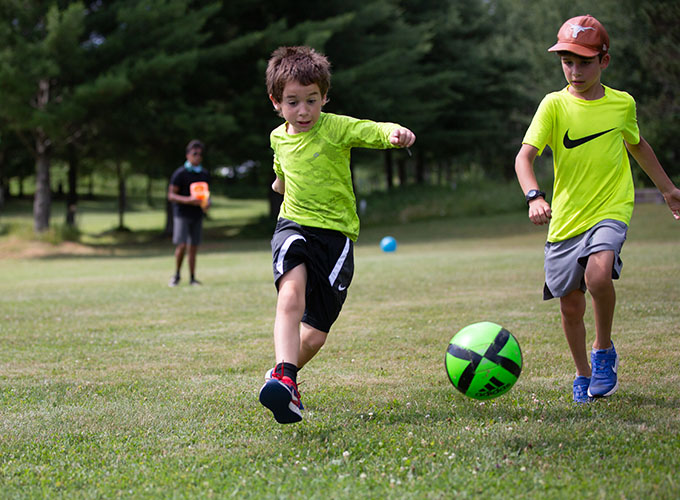 Two campers run in an attempt to intercept a soccer ball at North Star Camp for Boys.