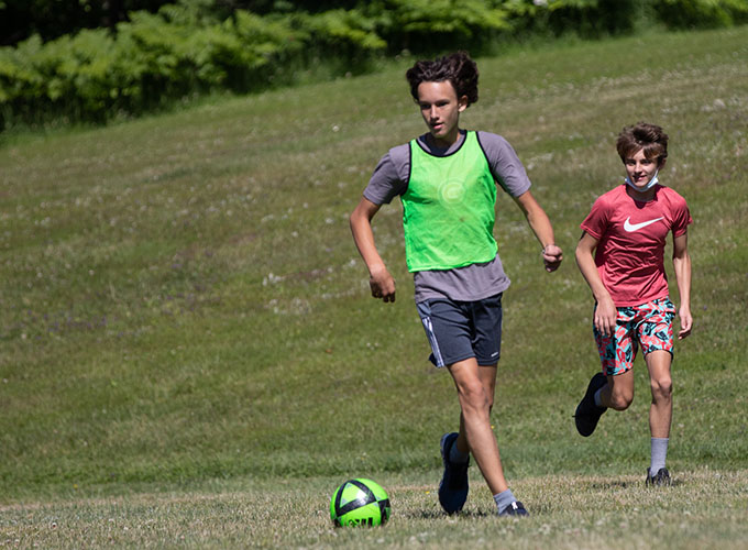 Two campers run while playing a game of soccer at North Star Camp for Boys.