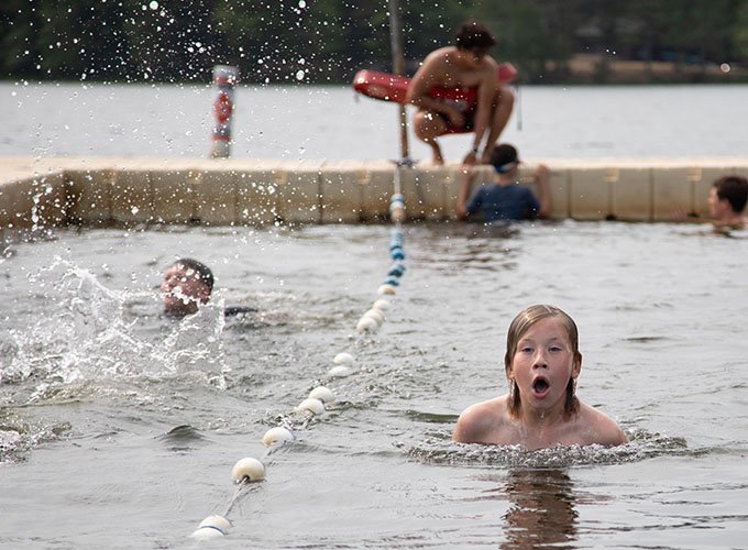 A camper bobs his head above and takes a breath of air during a butterfly stroke swimming exercise in Spider Lake at North Star Camp for Boys.