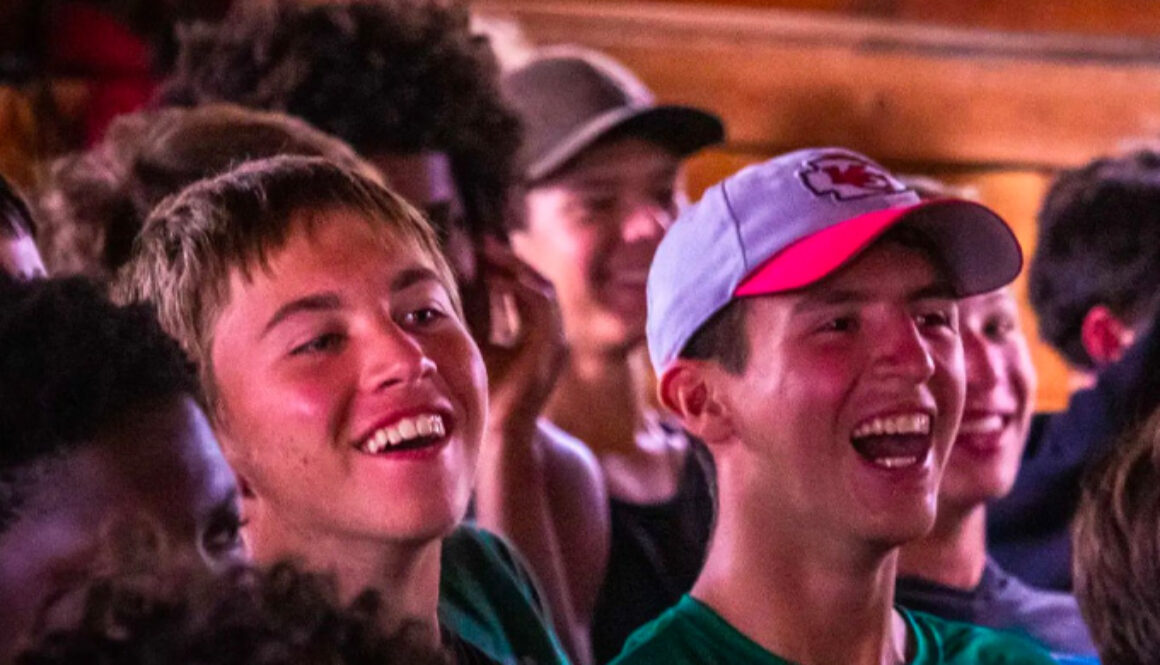 A group of audience members laugh during a theater performance at North Star Camp for Boys.