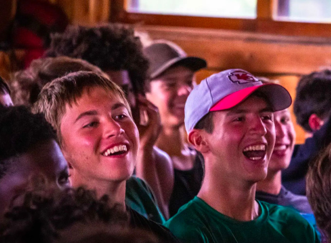 A group of audience members laugh during a theater performance at North Star Camp for Boys.