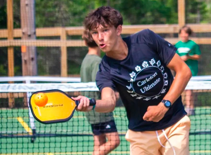 A camper hits a wiffle ball during a game of pickleball at North Star Camp for Boys.