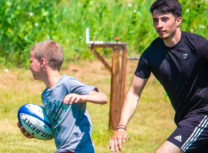 A camper and staff member participate in a game of speedball at North Star Camp for Boys.