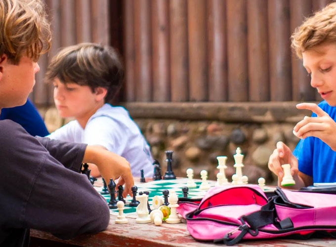Three campers at North Star Camp for Boys play a game of chess.