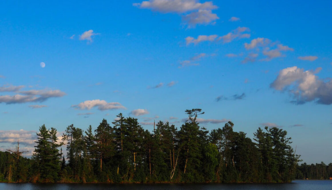 Scenic lake surrounded by green trees at North Star Camp for Boys.