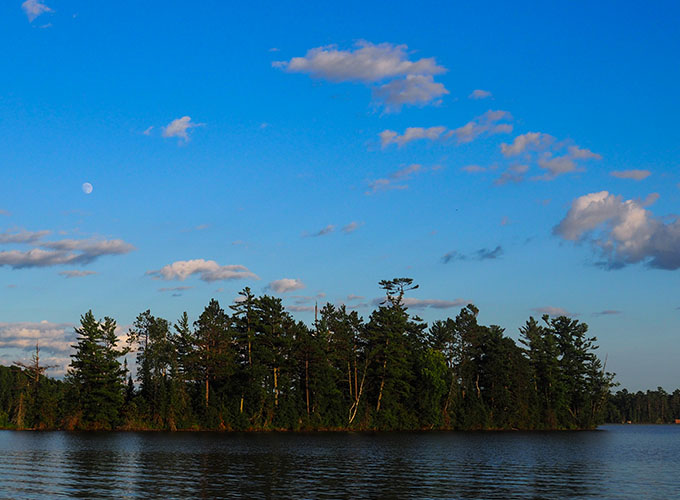 Scenic lake surrounded by green trees at North Star Camp for Boys.