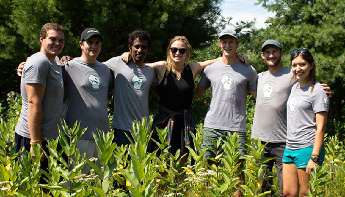 North Star Camp for Boys staff members wearing matching t-shirts smile for a picture while on a wilderness trip.