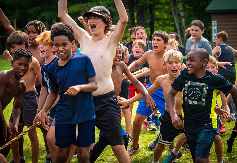 A group of campers cheer after winning a game of tug of war at North Star Camp for Boys.