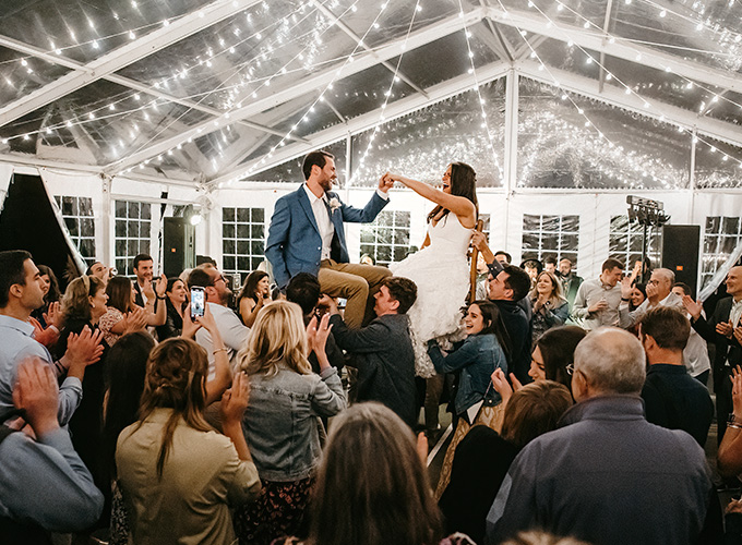 A newlywed celebrate their wedding at the North Star Camp for Boys facility by participating in The Hora, a Jewish wedding tradition where the newlyweds sit on chairs and are lifted into the air by their guests during their wedding reception.