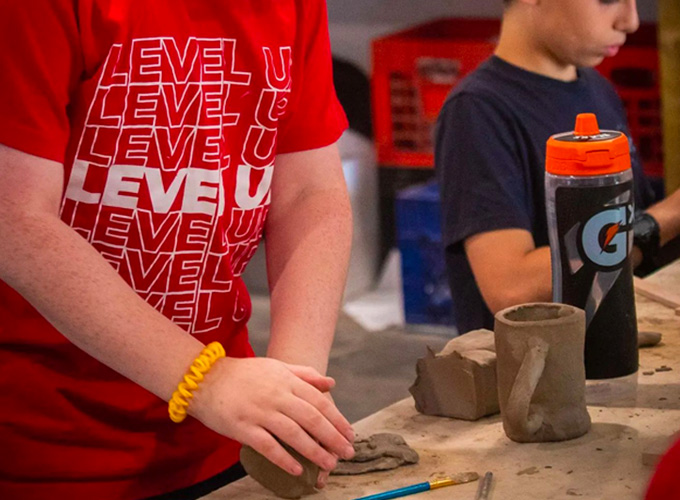 Two campers at North Star Camp for Boys knead clay during a ceramics activity.