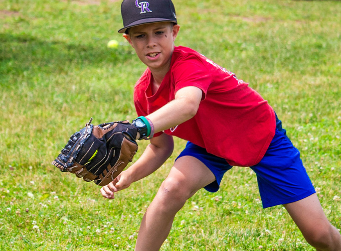 A camper gets ready to catch an incoming softball during a softball game at North Star Camp for Boys.