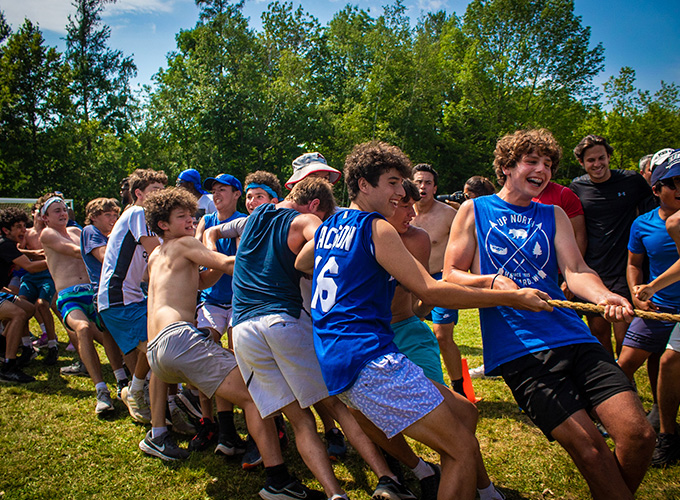 Campers laugh and smile while participating in a game of tug-of-war at North Star Camp for Boys.