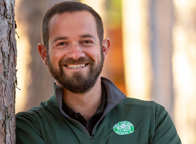 Owner and Director, Andy Shlensky, smiles for a headshot photo.