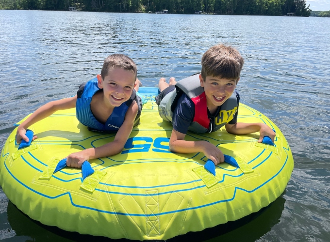 Two boys smile and get ready to go tubing during Family Camp at North Star Camp For Boys.