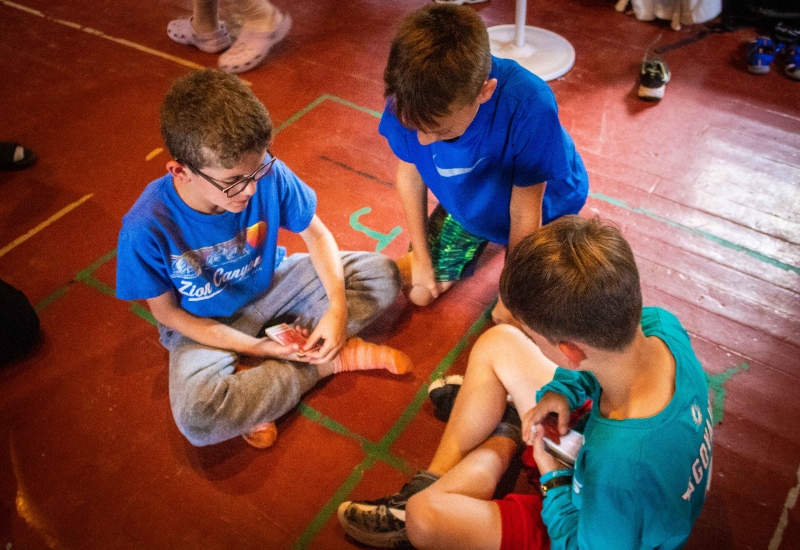 North Star Camp For Boys campers play a game of cards in their cabin.