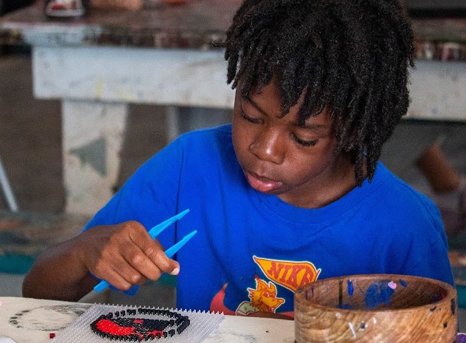 A North Star Camp camper works on an arts & crafts project at camp.