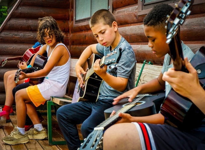 A group of North Star Camp campers play guitar during an activity period.