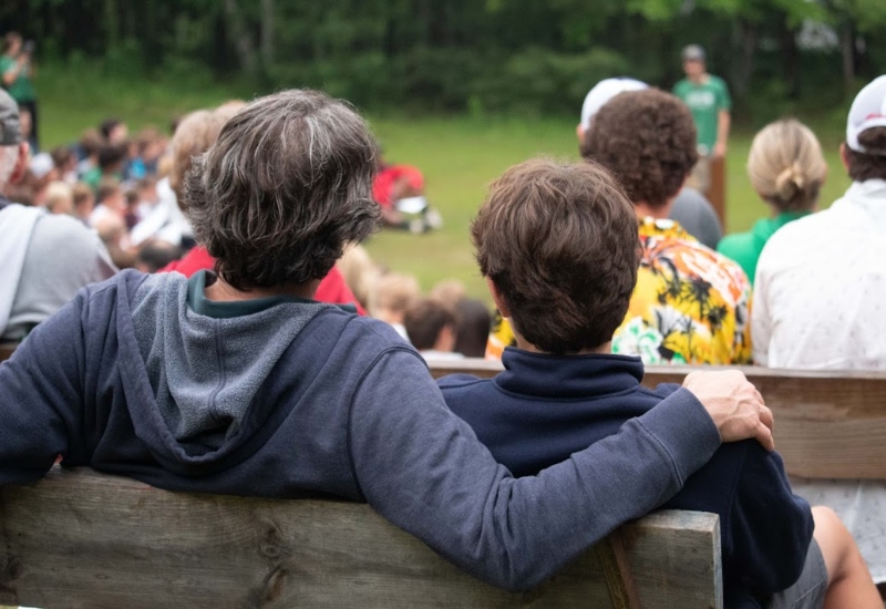 A father and son embrace while enjoying a campfire at North Star Camp for visiting day weekend.