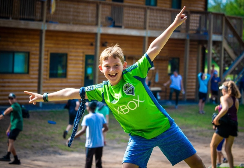 A North Star Camp camper smiles and poses for the camera during a summer camp game.