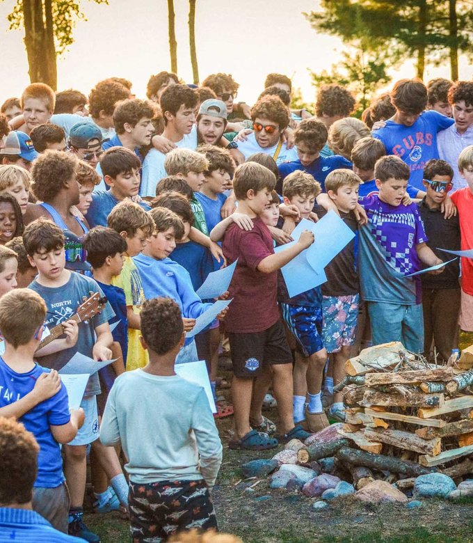 Campers build a campfire together before an evening program.