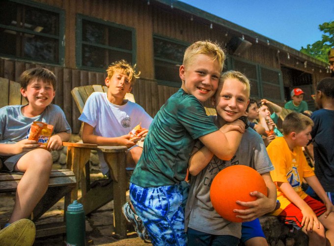 Campers laugh together outside the cabin during free time.