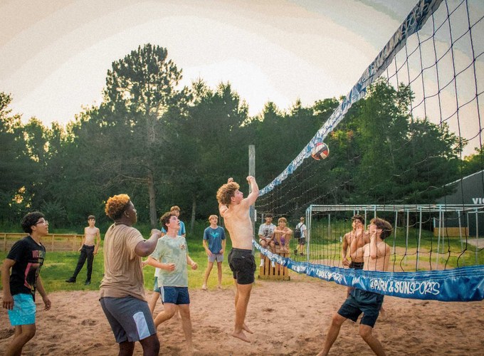 Campers play a game of sand volleyball.